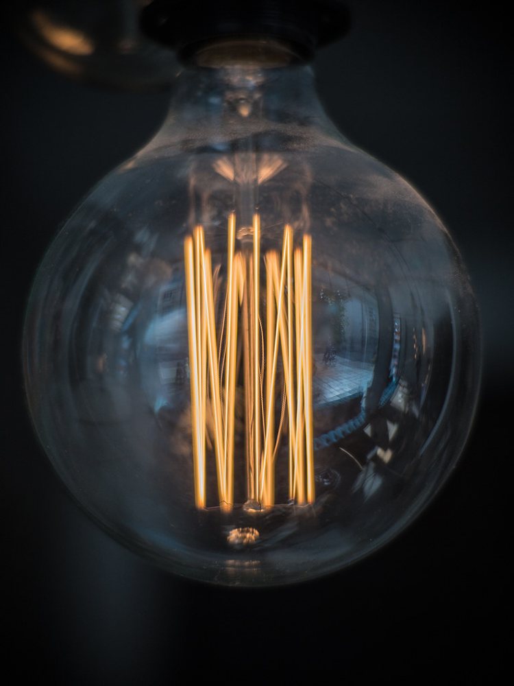 Close-up shot of glowing filaments in an incandescent light bulb