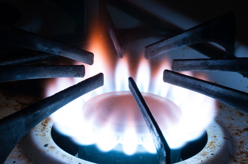 Burning gas stovetop in darkened room - closeup