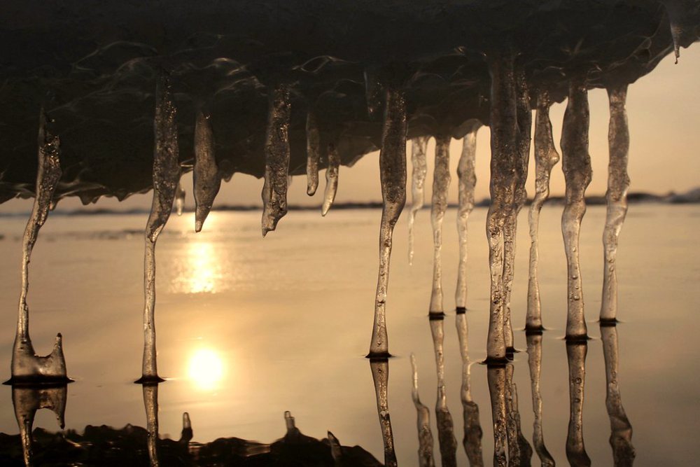 Ice sculptures and sunset in a frozen beach of the Baltic sea