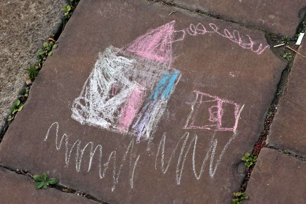 Children chalk drawing of a house on the pavement